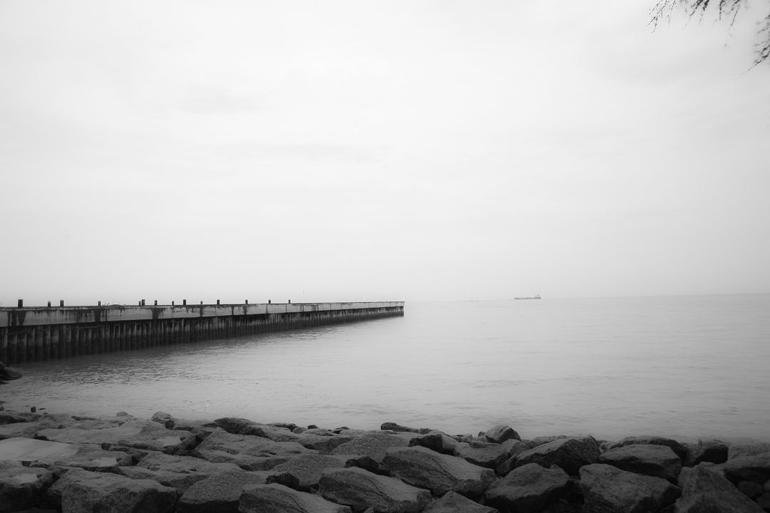 Tranquil Foggy Seaside with Rocky Shore and Pier - Free Images, Stock Photos and Pictures on Pikwizard.com