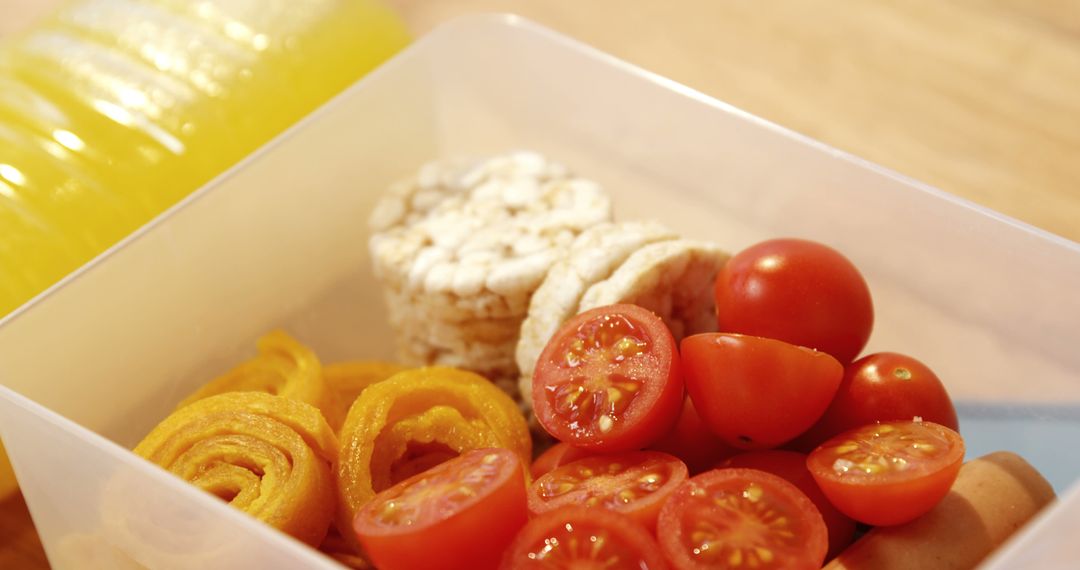 Promote healthy eating with a lunchbox packed with cherry tomatoes, rice cakes, and veggies. - Free Images, Stock Photos and Pictures on Pikwizard.com