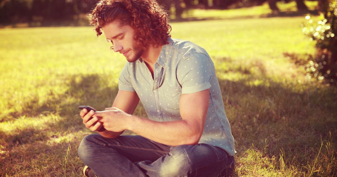 Young Man Relaxing in Park While Using Smartphone - Free Images, Stock Photos and Pictures on Pikwizard.com