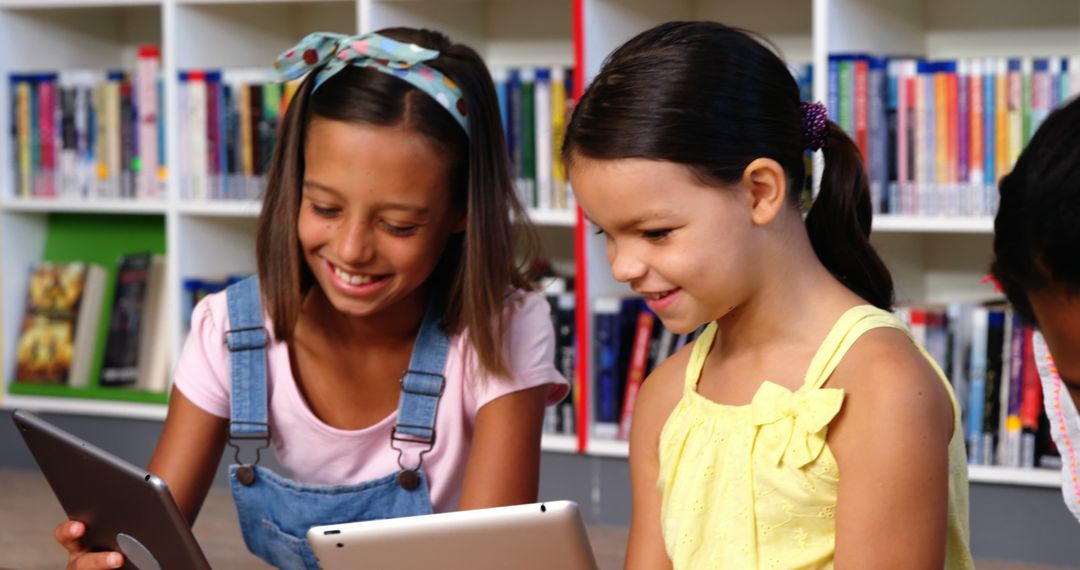 Smiling Young Girls Using Tablets in School Library - Free Images, Stock Photos and Pictures on Pikwizard.com