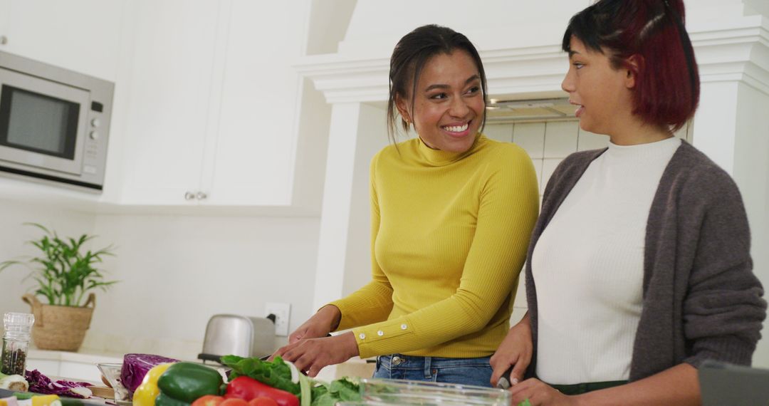 Two women preparing fresh vegetables in modern kitchen, smiling and talking together - Free Images, Stock Photos and Pictures on Pikwizard.com