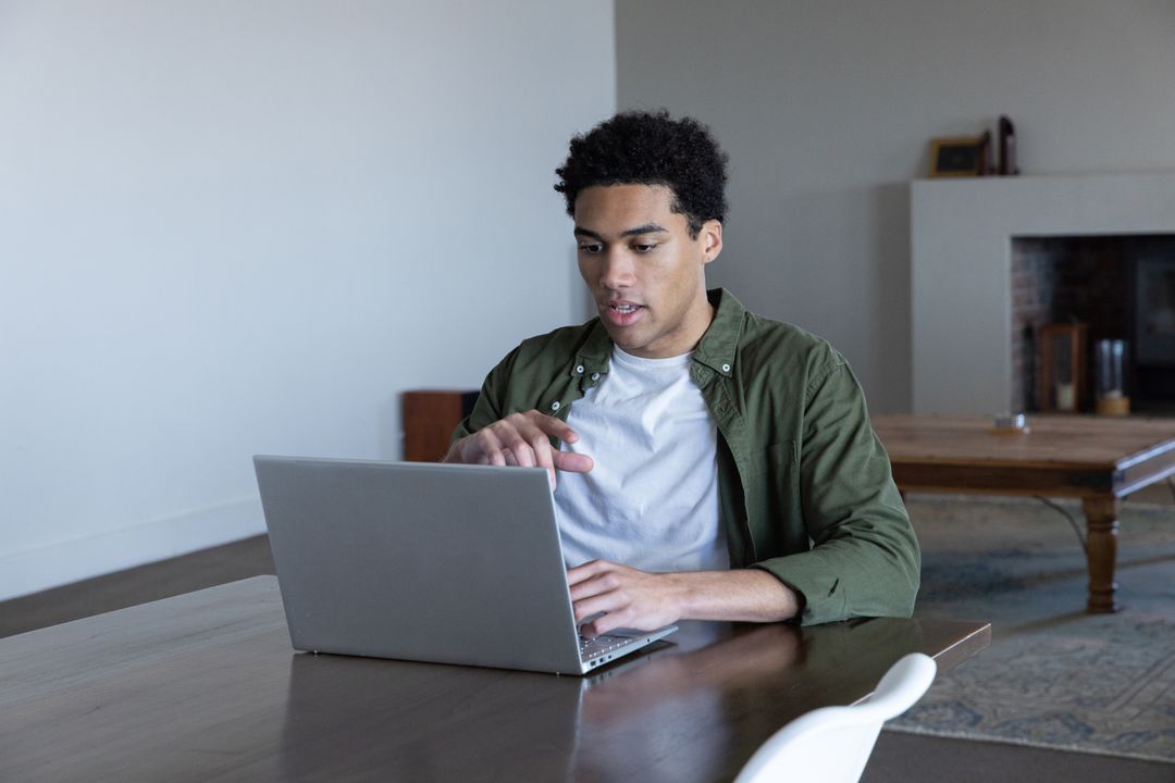 Focused Man Working on Laptop in Cozy Home Setting