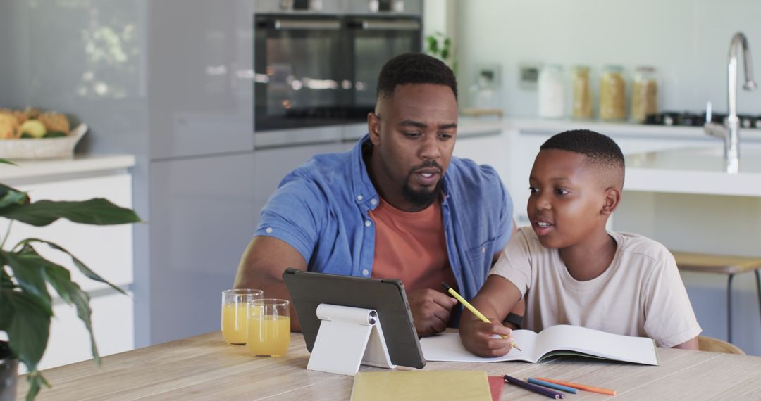 Father and Son Engaging in Learning Activity at Kitchen Table