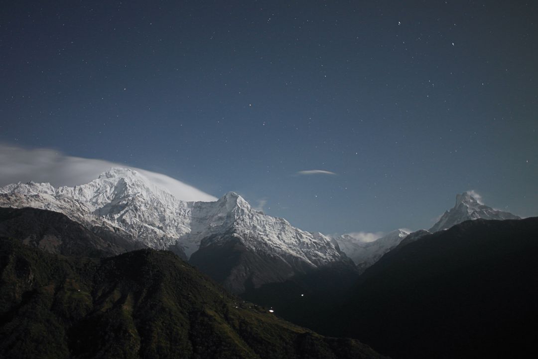 Snow-Covered Mountain Peaks at Night Under a Starry Sky - Free Images, Stock Photos and Pictures on Pikwizard.com