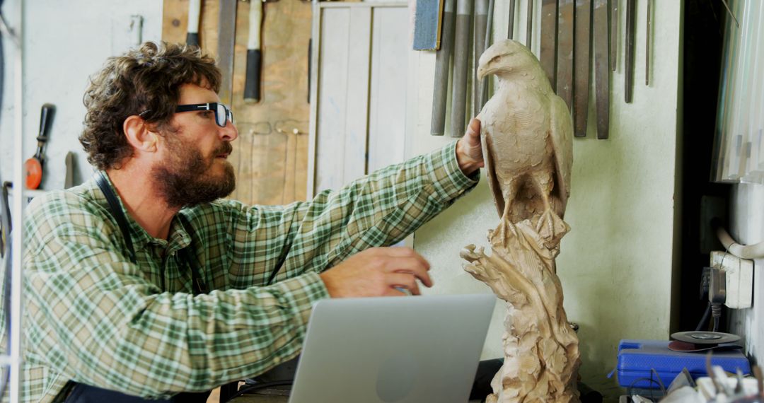 A Caucasian middle-aged man engages with a sculpture in a workshop environment, with copy space - Free Images, Stock Photos and Pictures on Pikwizard.com