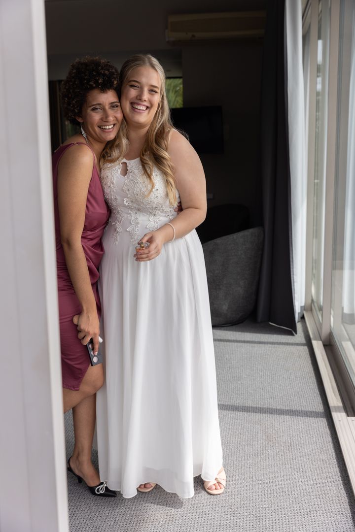 Bride and Bridesmaid Embracing in Elegant Hotel Setting