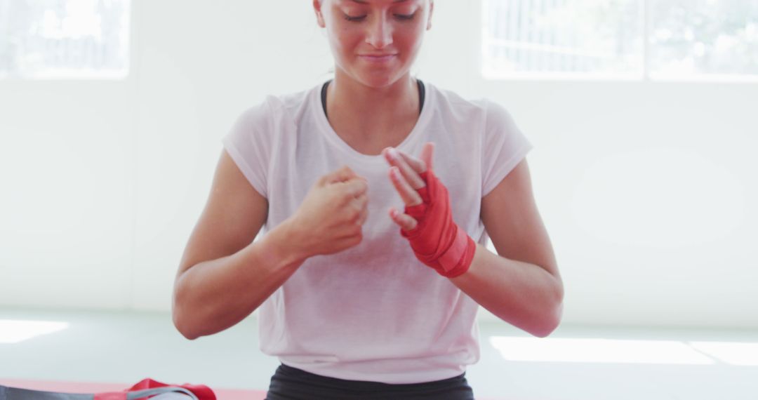 Confident Female Boxer Wrapping Hands in Gym - Free Images, Stock Photos and Pictures on Pikwizard.com