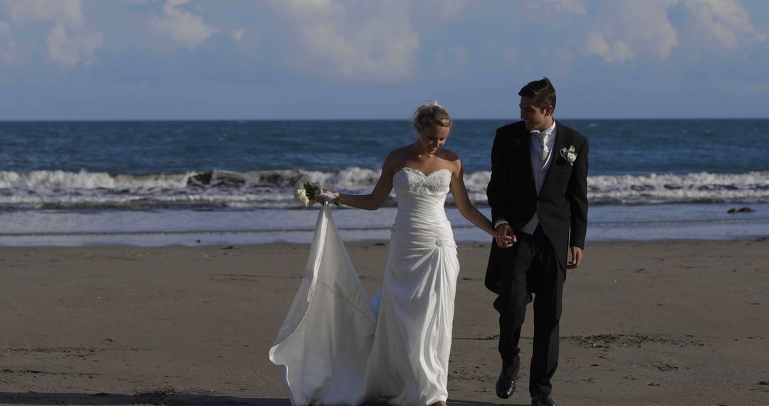 Newlywed Couple Holding Hands on Beach Wedding at Sunset - Free Images, Stock Photos and Pictures on Pikwizard.com