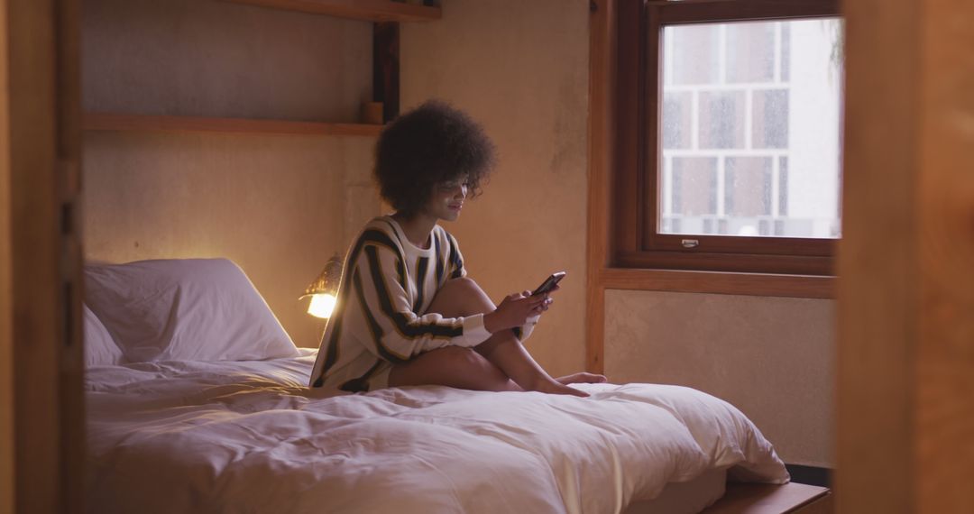 Relaxing in Cozy Bedroom While Engaging with Smartphone