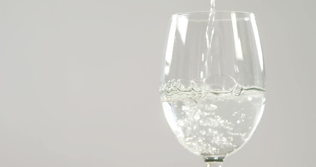 Close-Up of Sparkling Water Being Poured into Glass on White Background - Free Images, Stock Photos and Pictures on Pikwizard.com