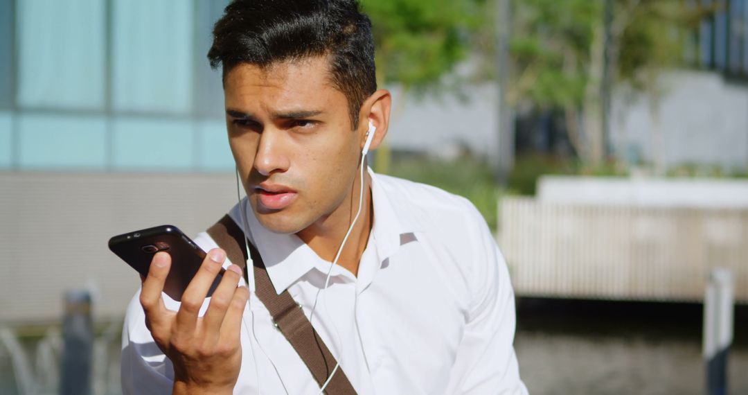 Young Professional Man Talking on Smartphone with Earphones - Free Images, Stock Photos and Pictures on Pikwizard.com