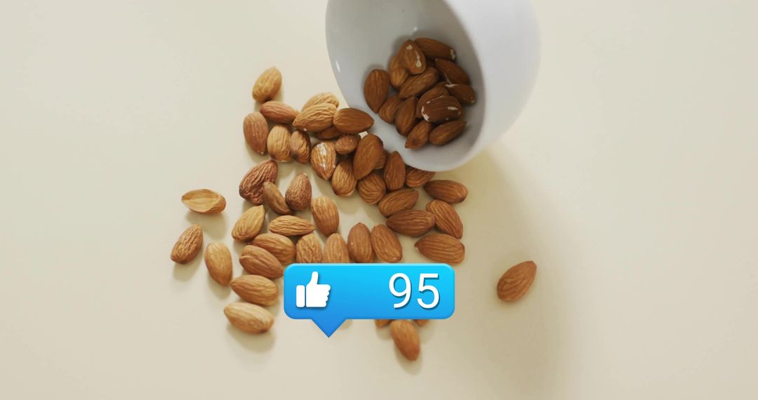 Scattered Almonds with Social Media Like Icon on Cream Background