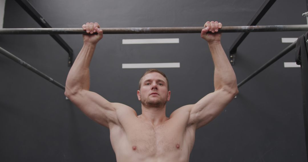 Athletic Man Performing Chin Ups in Gym Building Strength