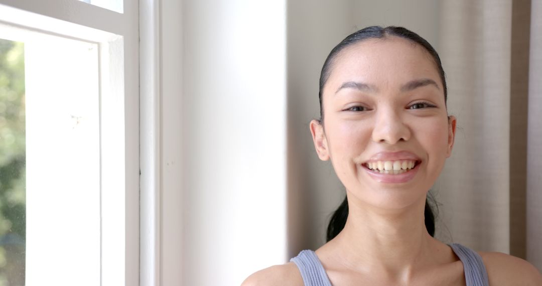 Joyful Woman Near Window Radiated by Natural Light