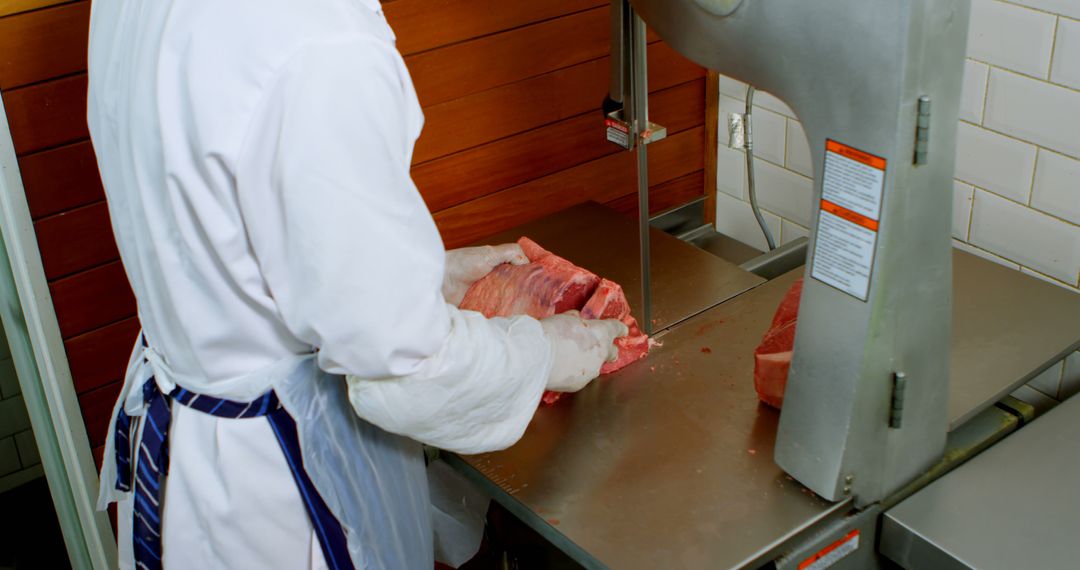 Butcher Cutting Meat with Large Industrial Meat Cutter - Free Images, Stock Photos and Pictures on Pikwizard.com