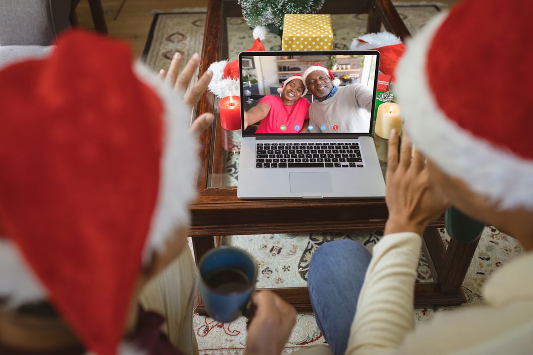 Diverse couple with santa hats having video call with happy african american couple - Free Images, Stock Photos and Pictures on Pikwizard.com
