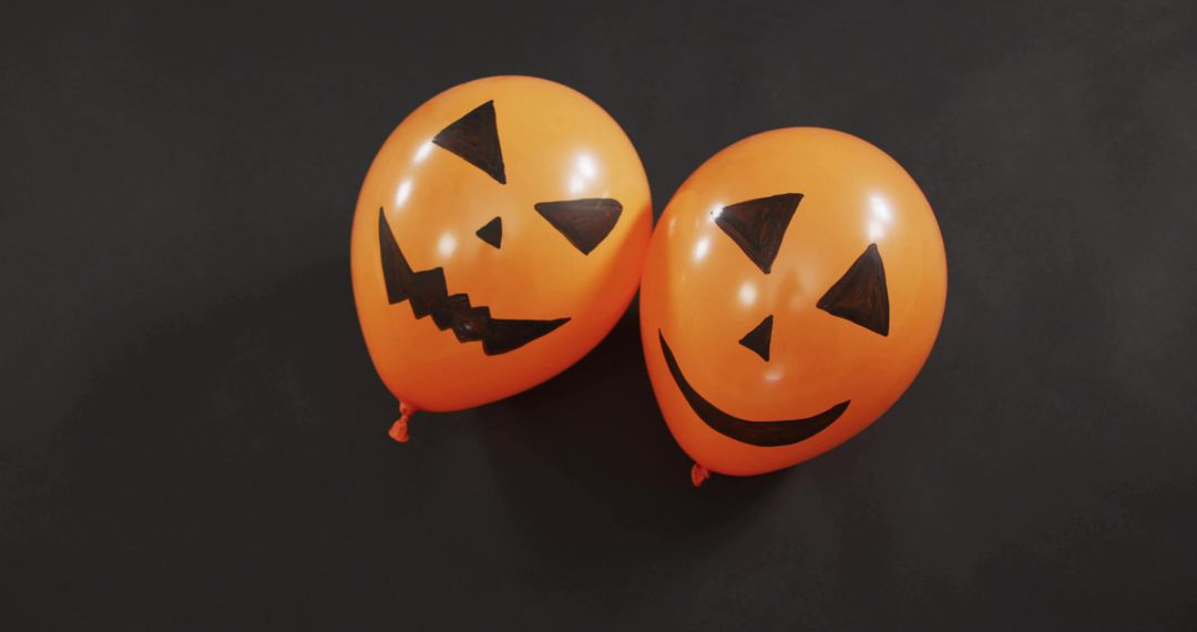 Displaying Paired Orange Jack-O'-Lantern Balloons on Dark Background for Halloween Decor