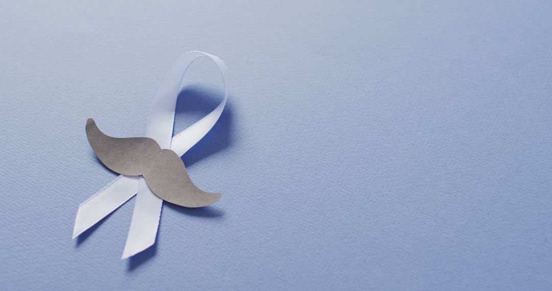 Image of paper moustache and pale blue prostate cancer ribbon on pale blue background - Free Images, Stock Photos and Pictures on Pikwizard.com