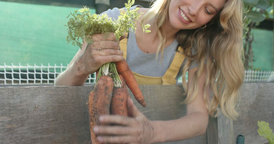 Farmwoman Harvesting Fresh Carrots with Long Blonde Hair and Smile - Free Images, Stock Photos and Pictures on Pikwizard.com