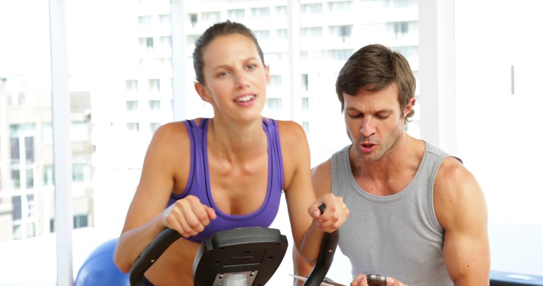 Personal Trainer Motivating Woman on Exercise Bike at Gym - Free Images, Stock Photos and Pictures on Pikwizard.com