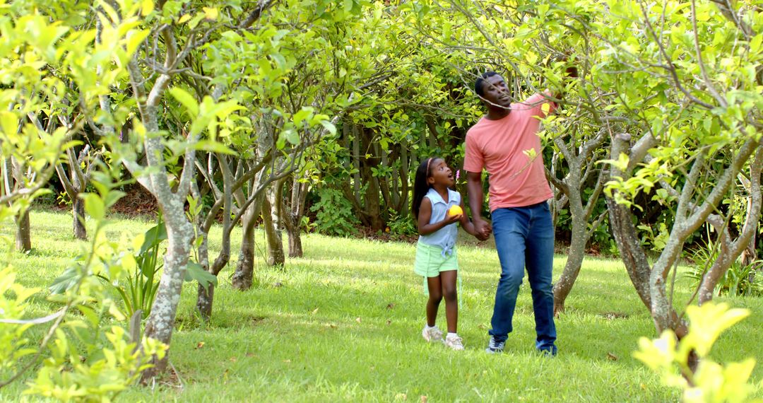 Father and Daughter Picking Lemons in Sunny Orchard