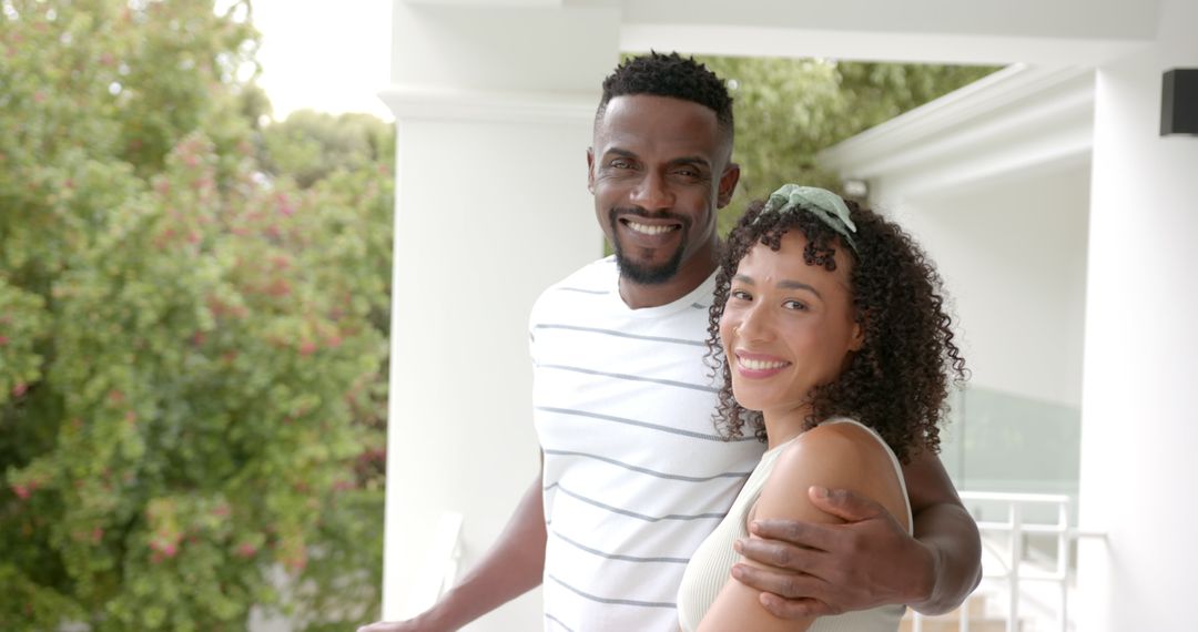 Smiling Couple Embracing on Balcony Enjoying Time Together
