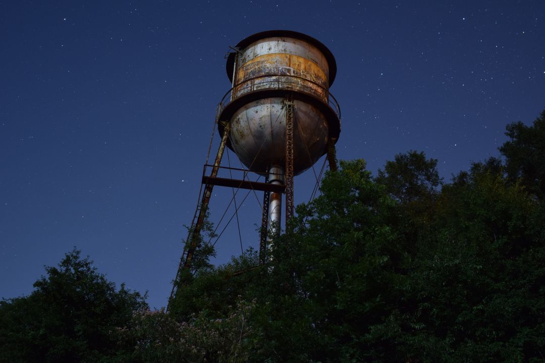 Rusty Water Tower Under Starry Night Sky in Forest - Free Images, Stock Photos and Pictures on Pikwizard.com