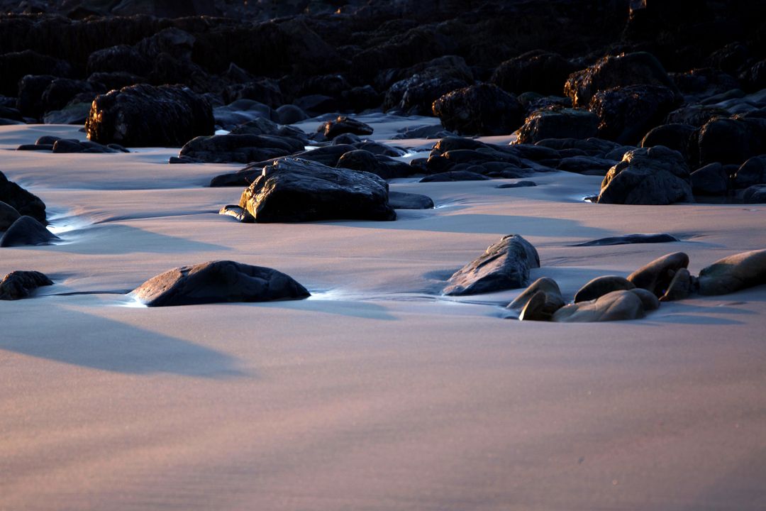 Sunset Light Painting Wet Sand and Volcanic Rocks at Low Tide