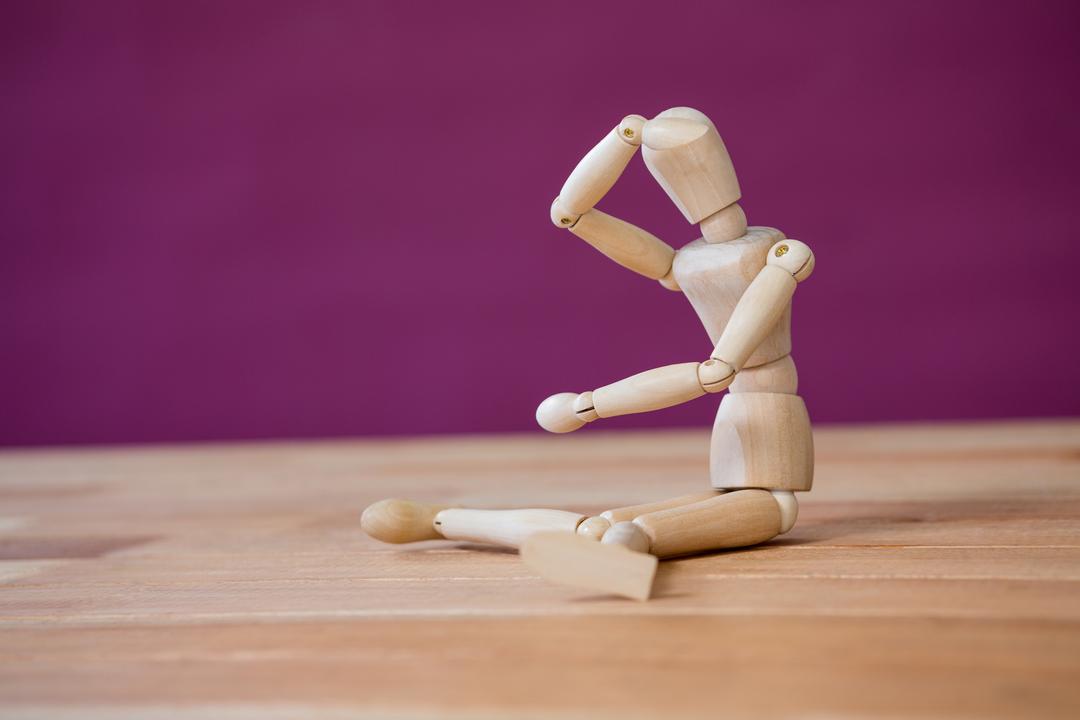 Wooden Art Mannequin Stretching on Wooden Surface - Free Images, Stock Photos and Pictures on Pikwizard.com