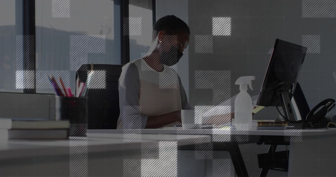 Office Professional in Face Mask Reviewing Documents on Computer