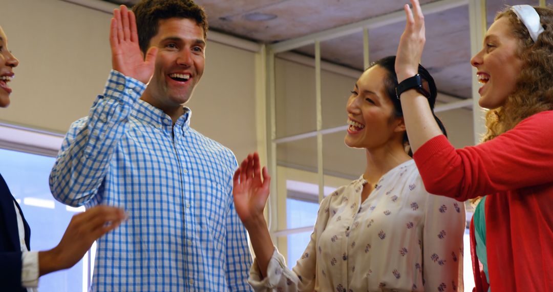 Cheerful Coworkers High-Fiving in Modern Office - Free Images, Stock Photos and Pictures on Pikwizard.com