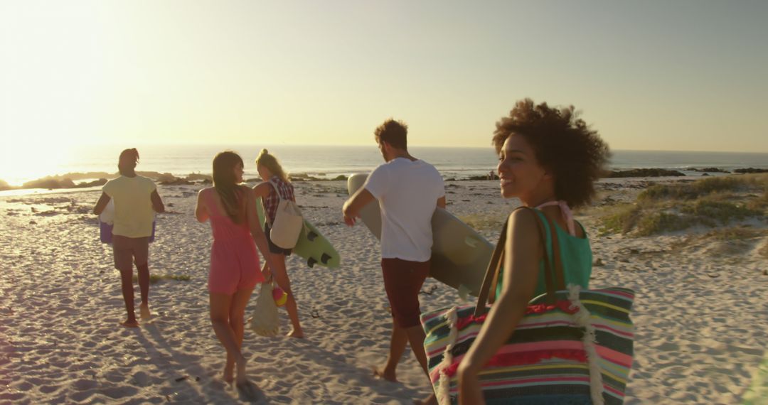 Group of Friends Walking on Beach during Sunset Holding Surfboards - Free Images, Stock Photos and Pictures on Pikwizard.com