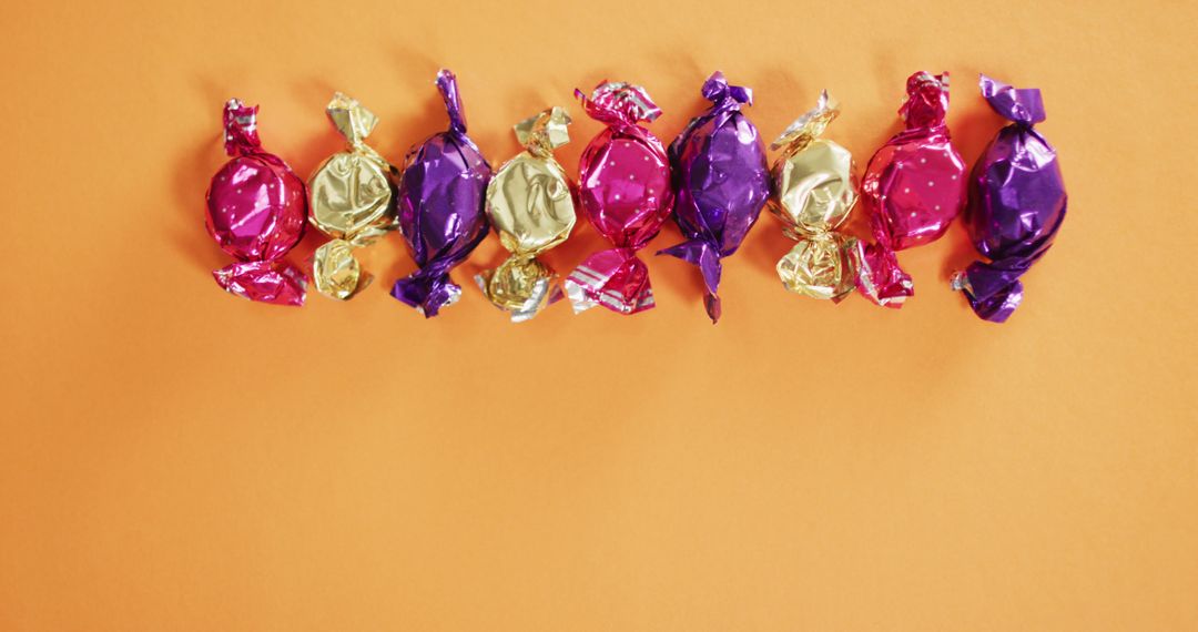 Colorful Wrapped Candy on Bright Orange Background - Free Images, Stock Photos and Pictures on Pikwizard.com