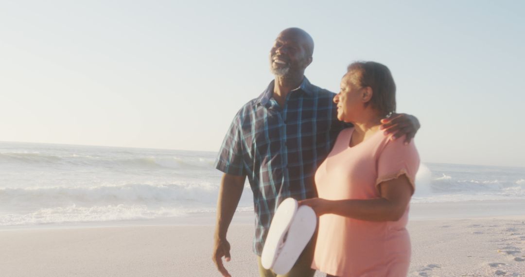 Happy Older Couple Walking on Beach Smiling - Free Images, Stock Photos and Pictures on Pikwizard.com