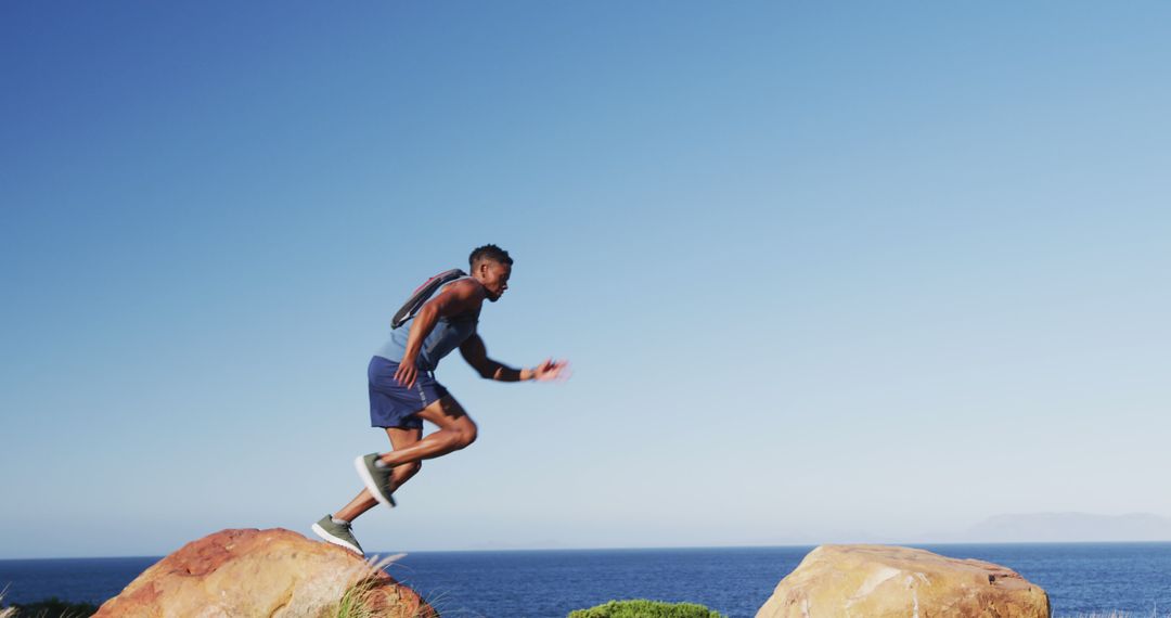 African american man exercising outdoors jumping on rocks in countryside on a mountain - Free Images, Stock Photos and Pictures on Pikwizard.com