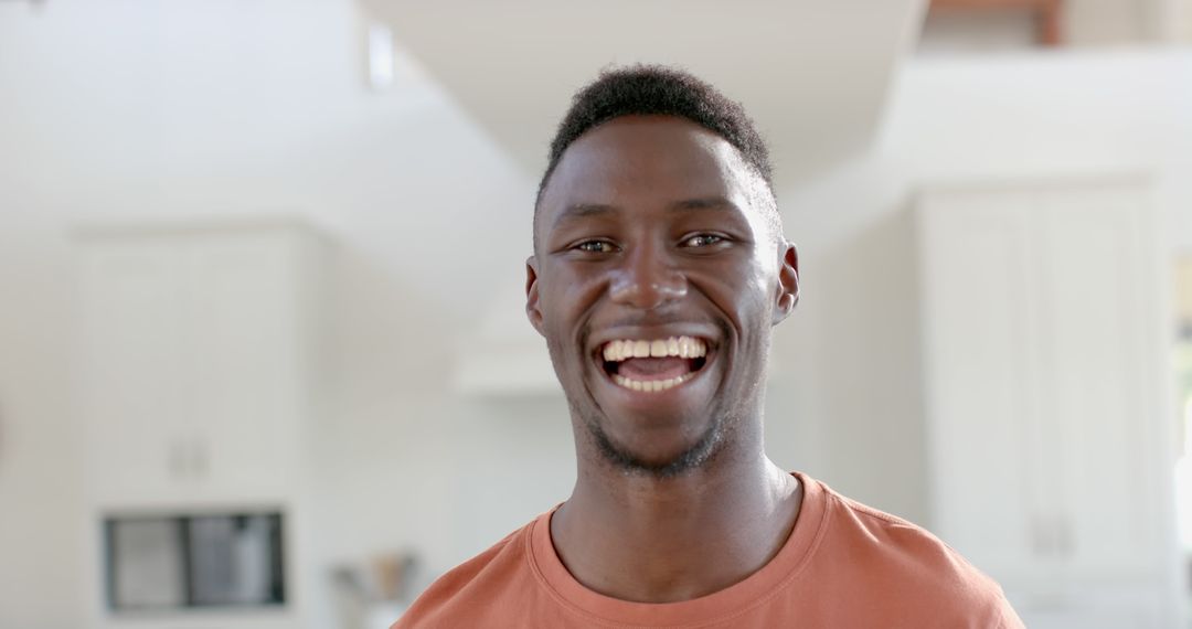 Cheerful Man Smiling in Bright Modern Kitchen - Free Images, Stock Photos and Pictures on Pikwizard.com