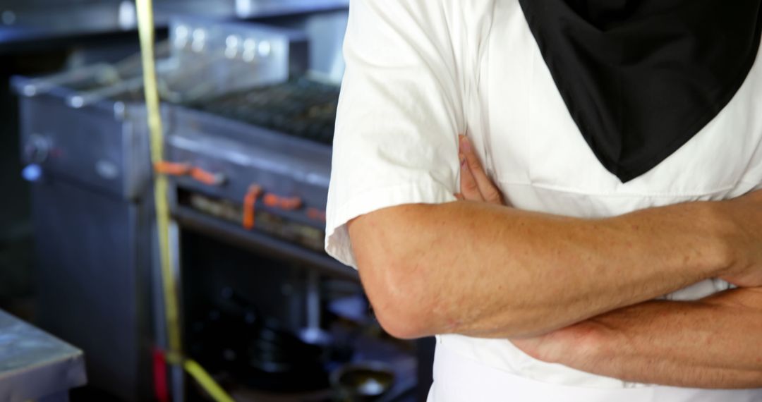 Chef Standing with Crossed Arms in Commercial Kitchen - Free Images, Stock Photos and Pictures on Pikwizard.com