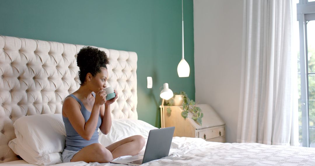 Woman Relaxing in Bed with Coffee and Laptop in Modern Bedroom - Free Images, Stock Photos and Pictures on Pikwizard.com