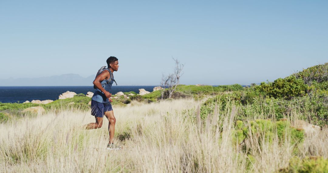 Man Running Through Wilderness on Sunny Day - Free Images, Stock Photos and Pictures on Pikwizard.com