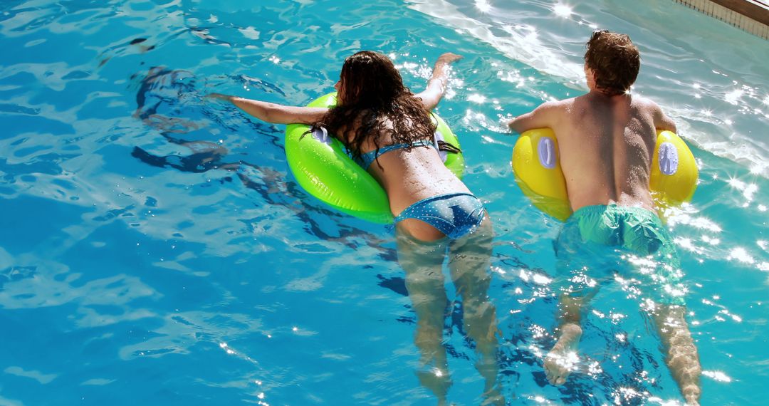 Couple Enjoying Summer Pool Fun on Inflatable Floats - Free Images, Stock Photos and Pictures on Pikwizard.com