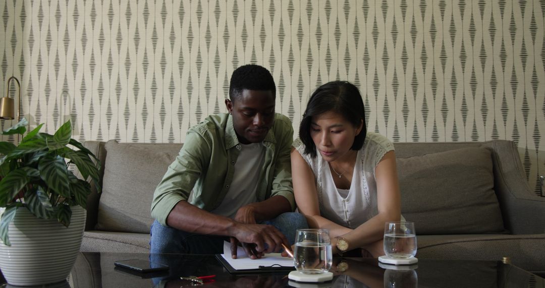 Diverse Colleagues Collaborating on Review in Cozy Living Space