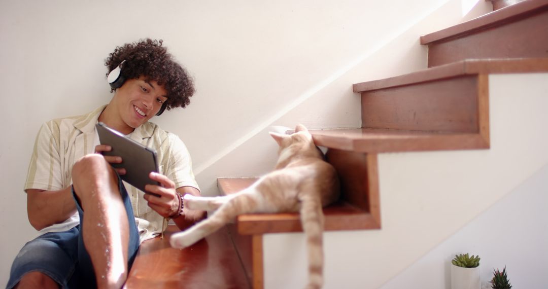Young Man Relaxing with Tablet and Cat on Minimalist Wood Stairs