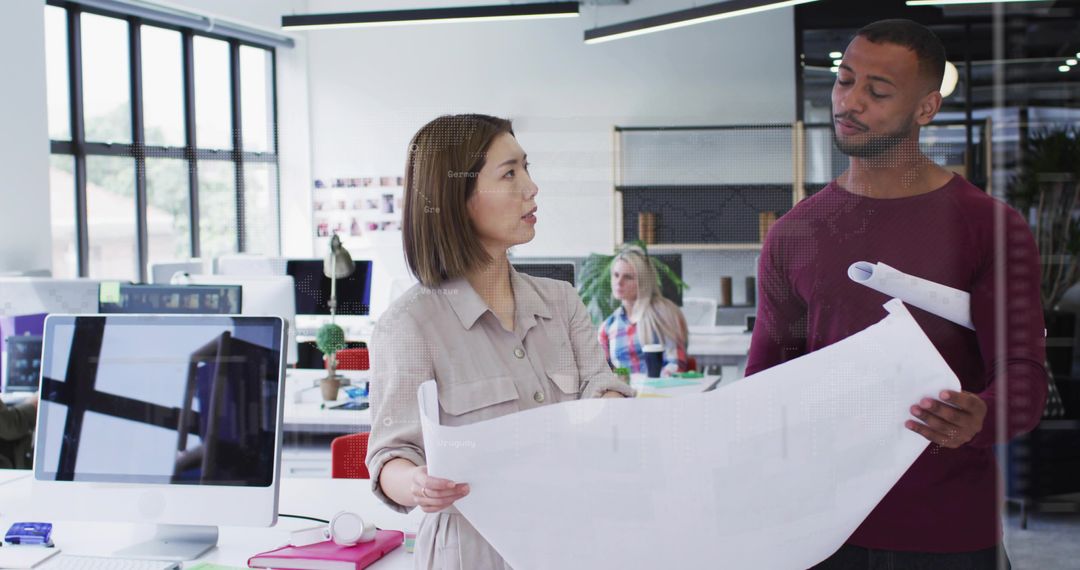 Multicultural Professionals Reviewing Architectural Blueprint in Modern Open-plan Office