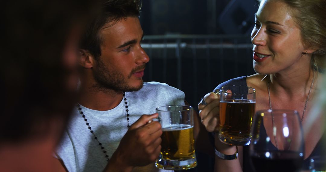 Young Couple Enjoying Beer and Conversation in Bar