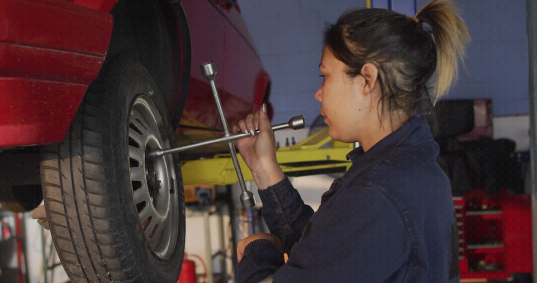 Female Mechanic Repairing Car with Tools in Workshop