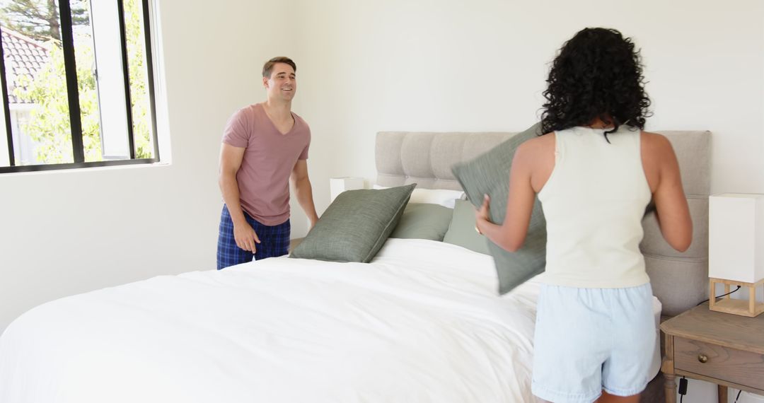 Couple Collaborating in Making Bed at Home