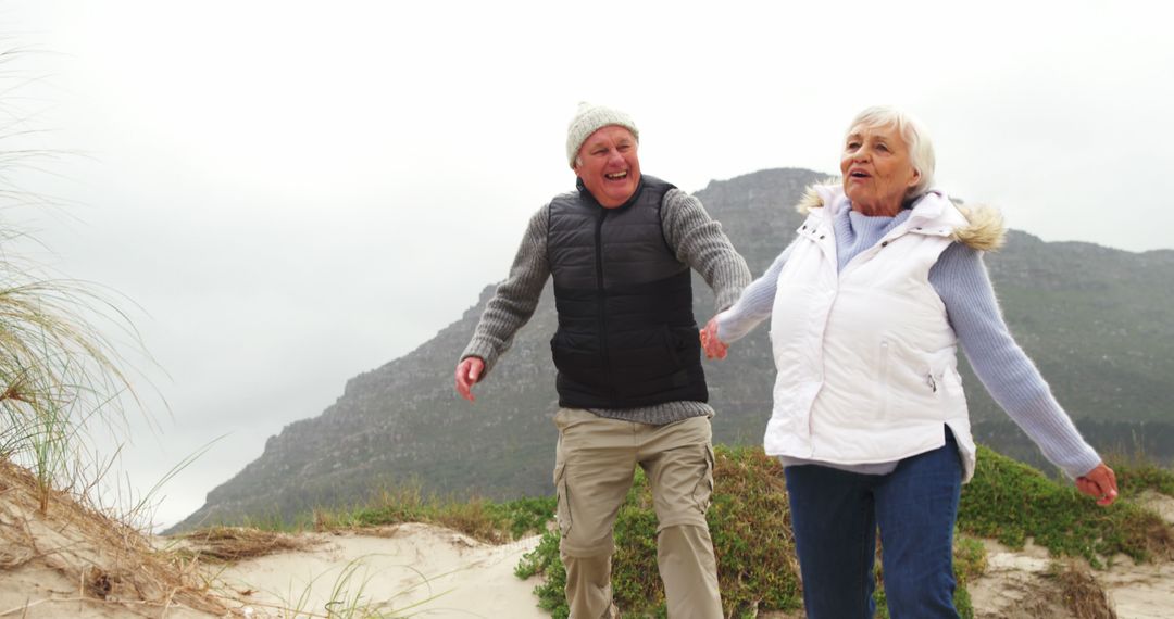 Happy Senior Couple Walking on Beach Hiking Adventure - Free Images, Stock Photos and Pictures on Pikwizard.com