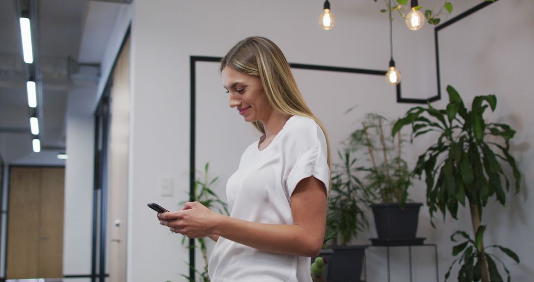 Portrait of caucasian woman smiling while using smartphone at office - Free Images, Stock Photos and Pictures on Pikwizard.com