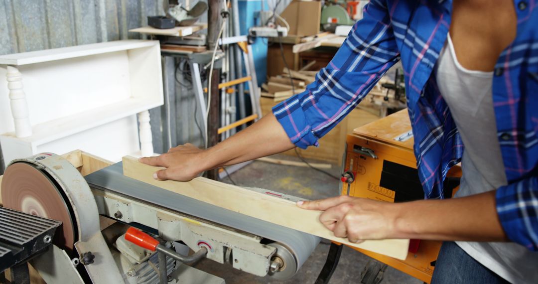 Woman Sanding Wood Plank in Workshop, Engaged in Carpentry - Free Images, Stock Photos and Pictures on Pikwizard.com