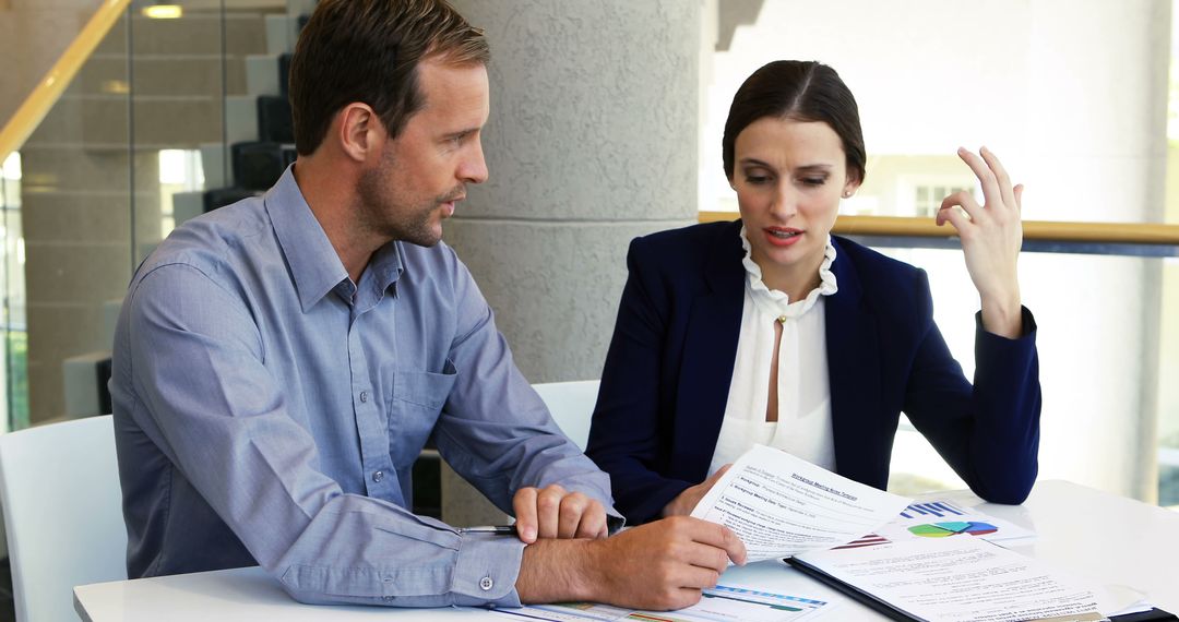 Focused Business Professionals Discussing Reports in Modern Office